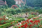 THE PRIORY  BEECH HILL  BERKSHIRE: THE NEW ROSE PARTERRE WITH BOX EDGING  STONE URN WITH PHORMIUM AND WHITE BEGONIAS  HOUSE IN THE BACKGROUND