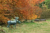 BATSFORD ARBORETUM  GLOUCESTERSHIRE: A BRONZE STAG AND HIND BESIDE A BEECH TREE
