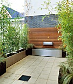 ROOF TERRACE: WOOD AND METAL  WATER FEATURE WITH METAL WATER SPOUT SURROUNDED BY METAL CONTAINERS PLANTED WITH BAMBOO. DESIGNERS: WYNNIATT-HUSEY CLARKE