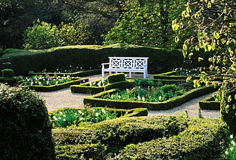 KELMARSH_HALL__NORTHAMPTONSHIRE_A_WHITE_WOODEN_SEAT_AND_BOX_HEDGING_IN_THE_SUNKEN_GARDEN