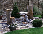 A PLACE TO SIT: WOODEN SEAT AND TABLE ON STONE FLOOR. JOHN MASSEYS GARDEN  WORCESTERSHIRE