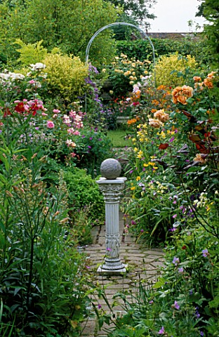 WOODCHIPPINGS__NORTHANTS_VISTA_THROUGH_THE_CIRCLE_TO_A_WHITE_ARCH_WITH_ROSES_AND_AQUILEGIAS