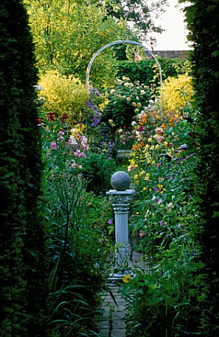 WOODCHIPPINGS__NORTHANTS_VISTA_THROUGH_THE_CIRCLE_TO_A_WHITE_ARCH_WITH_ROSES_AND_AQUILEGIAS