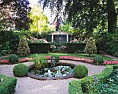 AMSTERDAM: PRIVATE GARDEN WITH BOX HEDGING  SUMMERHOUSE  CLIPPED HOLLIES  BEDDING BEGONIAS  POOL AND CUPID WATER FOUNTAIN