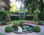 AMSTERDAM: PRIVATE GARDEN WITH BOX HEDGING  SUMMERHOUSE  CLIPPED HOLLIES  BEDDING BEGONIAS  POOL AND CUPID WATER FOUNTAIN