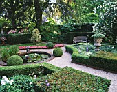 AMSTERDAM: PRIVATE GARDEN WITH BOX HEDGING  CLIPPED HOLLIES  BEDDING BEGONIAS  POOL AND CUPID WATER FOUNTAIN  STONE URN AND WOODEN BENCH