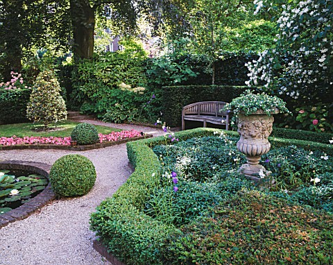 AMSTERDAM_PRIVATE_GARDEN_WITH_BOX_HEDGING__CLIPPED_HOLLIES__BEDDING_BEGONIAS__STONE_URN_AND_WOODEN_B
