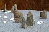 DESIGNERS R. KETCHELL AND JACQUIE BLAKELEY: MOMOTARO (JAPANESE) GARDEN - ROCKS AND STONES IN GRAVEL GARDEN WITH WOVEN WILLOW FENCING