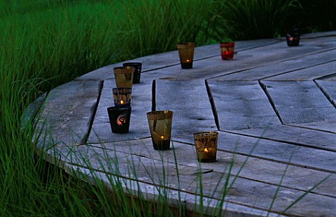 DESIGNER_CLARE_MATTHEWS_THE_DECK_CHAIR_AT_DUSK_WITH_CANDLES__SURROUNDED_BY_STIPA_ARUNDINACEA