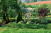 PETTIFERS GARDEN  OXFORDSHIRE: THE PARTERRE IN SPRING WITH MALUS HUPEHENSIS BEHIND