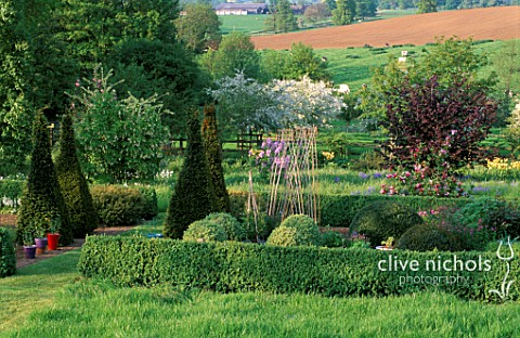 PETTIFERS_GARDEN__OXFORDSHIRE_THE_PARTERRE_IN_SPRING_WITH_MALUS_HUPEHENSIS_BEHIND