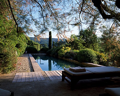 LA_CHABAUDE__FRANCE_DESIGNER__PHILIPPE_COTTET_THE_SWIMMING_POOL_WITH_DECKING__SUNLOUNGERS_AND_COUNTR