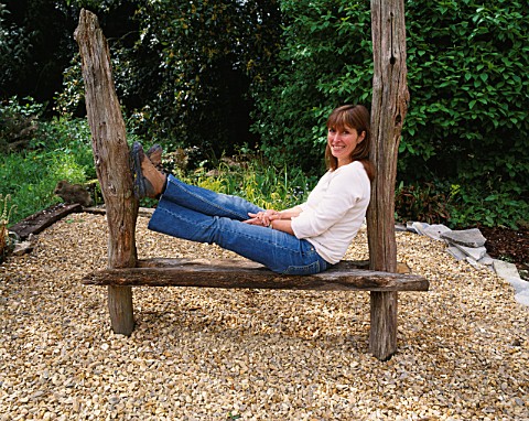 DESIGNER_CLARE_MATTHEWS_SITS_ON_A_HOME_MADE_WOODEN_SEAT