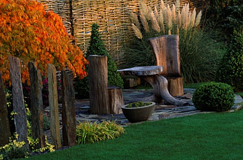 SLATE_TERRACE_BESIDE_WILLOW_FENCE_WITH_OAK_CHAIRS_AND_TABLE__ACER_PALMATUM_DISSECTUM_AND_BOX_TOPIARY