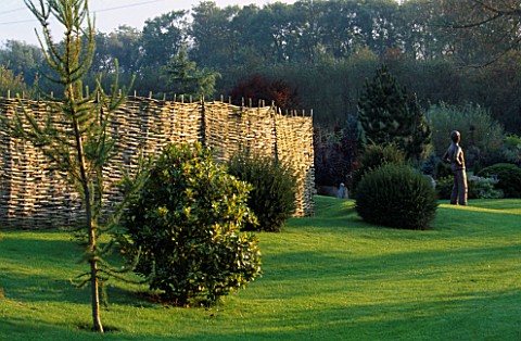 LAWN__YEW_BALLS__WILLOW_FENCE_AND__BRONZE_STATUE_BY_JANE_HOGBEN_DESIGNER_JOHN_MASSEY