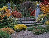 ENTRANCE TO PAVED GARDEN  SURROUNDED BY  AUTUMNAL BORDER  DESIGNER: BRIAN CROSS  LAKEMOUNT  IRELAND