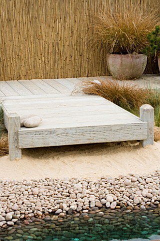 TERRACOTTA_CONTAINER_ON_DECKING_IN_SEASIDE_GARDEN_PLANTED_WITH_GRASSES_DESIGNERS_NIGEL_DUFF_AND_GREG