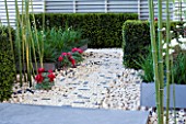 CHUNKS OF LIMESTONE FORM MULCH AROUND PAEONIA AND BLOCK PATH IN HIS LATE HIGHNESS SHAIKH ZAYED BIN SULTAN AL-NAYHANS GARDEN BY CHRISTOPHER BRADLEY-HOLE. CHELSEA 2005