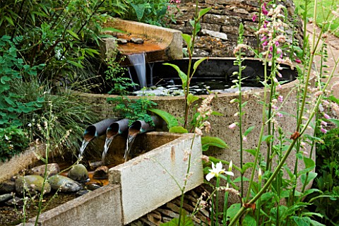 WATER_FEATURE_RILL_SPILLING_INTO_A_CIRCULAR_STONE_BASIN_AND_OUT_AGAIN_THROUGH_THREE_PIPES_INTO_ANOTH