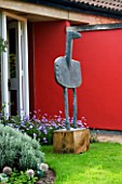 SEA BIRD SCULPTURE BY CHRIS MARVELL STANDS ON THE LAWN BY THE FRONT DOOR OF THE HOUSE WITH THE RED WALL. WINGWELL NURSERY  RUTLAND