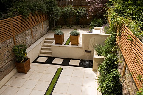 VIEW_ACROSS_CONTEMPORARY_CLASSIC_GARDEN_WITH_PLANTED_RILL__COPPER_WATER_FEATURE__PORTUGUESE_LIMESTON