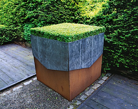 RIDLERS_GARDEN__SWANSEA__WALES_LEAD_AND_RUSTY_METAL_CONTAINER_PLANTED_WITH_BOX_TABLE__DESIGNER_TONY_