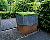 RIDLERS GARDEN  SWANSEA  WALES: LEAD AND RUSTY METAL CONTAINER PLANTED WITH BOX TABLE : DESIGNER: TONY RIDLER