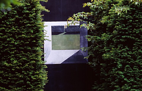 RIDLERS_GARDEN__SWANSEA__WALES_BLACK_WALL_WITH_PICTURE_BETWEEN_TWO_YEW_HEDGES_DESIGNER_TONY_RIDLER