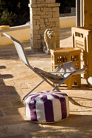 GINA_PRICES_GARDEN__CORFU_VIEW_ACROSS_THE_TERRACE_WITH_CUSHION_FROM_MOROCCO_AND_STONE_LION_FROM_INDI
