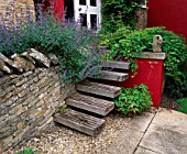 WINGWELL NURSERY  RUTLAND: WOODEN STEPS AT THE BACK OF THE HOUSE LEADING UP TO RED WALL