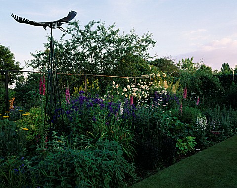 HALL_FARM__LINCOLNSHIRE_VIEW_ALONG_HERBACEOUS_BORDER_WITH_SCULPTURE_OF_EAGLE_BY_PAUL_GILBARD