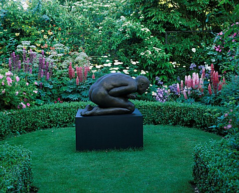 HALL_FARM__LINCOLNSHIRE_BRONZE_SCULPTURE_THE_FIRST_MAN_BY_TRACY_CHRISTIANSEN_IN_A_GARDEN_WITH_FOXGLO