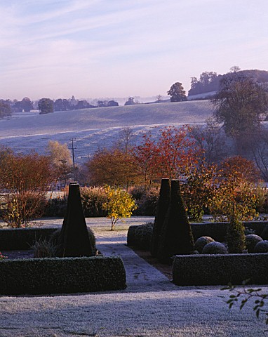 VIEW_ACROSS_PARTERRE_TO_OPEN_COUNTRYSIDE_WITH_RIDGE_AND_FURROW_FIELD__AT_PETTIFERS_IN__FROST__TOPIAR