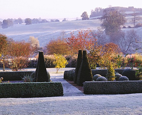 VIEW_ACROSS_PARTERRE_TO_OPEN_COUNTRYSIDE_WITH_RIDGE_AND_FURROW_FIELD__AT_PETTIFERS_IN__FROST__TOPIAR