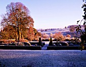 VIEW ACROSS FROSTED PARTERRE TO OPEN COUNTRYSIDE AT PETTIFERS.  TOPIARY