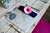DESIGN BY CLARE MATTHEWS: OUTDOOR TABLE SETTING WITH STONE TABLE MAT  GERBERA DECORATED NAPKIN AND STONE NAME SETTING