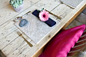 DESIGN BY CLARE MATTHEWS: OUTDOOR TABLE SETTING WITH STONE TABLE MAT  GERBERA DECORATED NAPKIN AND STONE NAME SETTING