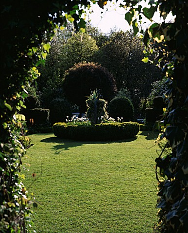 CHENIES_MANOR_GARDEN__BUCKINGHAMSHIRE_VIEW_INTO_THE_WHITE_GARDEN_IN_SPRING_WITH_BOX_AND_YEW_TOPIARY_