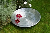 DESIGNER: CLARE MATTHEWS - SILVER REFLECTIVE BOWL ON LAWN BESIDE BORDER FILLED WITH WATER