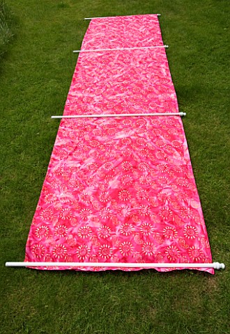 DESIGNER_CLARE_MATTHEWS_WIND_BREAK_SCREEN_PROJECT__SCREEN_AND_POLES_LAID_OUT_ON_LAWN