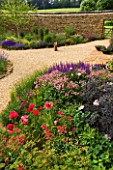 RICKYARD BARN GARDEN  NORTHAMPTONSHIRE: THE GRAVEL GARDEN WITH ROCKS AND BORDERS OF GRASSES AND PERENNIALS