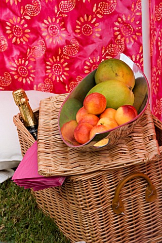 DESIGNER_CLARE_MATTHEWS_WIND_BREAK_SCREEN_PROJECT_HAMPER_AND_METAL_FRUIT_BOWL_WITH_PEACHES_AND_MANGO