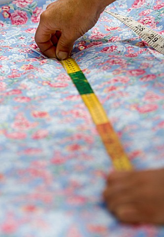 DESIGNER_CLARE_MATTHEWS_MEASURING_DISTANCE_BETWEEN_TWO_BUTTONS_ON_BED_ROLL