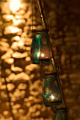 DESIGNER: CLARE MATTHEWS - LANTERN STAND PROJECT: WOODEN LANTERN STAND WITH GLASS JAR CANDLES AT NIGHT. LIGHTING