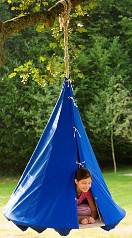 DESIGNER_CLARE_MATTHEWS__SWINGING_COCOON_PROJECT_GIRL_LOOKS_OUT_OF_BLUE_COCOON_HANGING_FROM_TREE