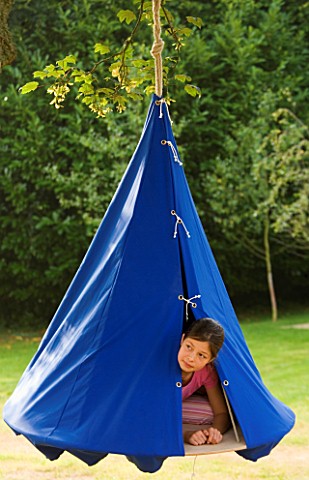 DESIGNER_CLARE_MATTHEWS__SWINGING_COCOON_PROJECT_GIRL_LOOKS_OUT_OF_BLUE_COCOON_HANGING_FROM_TREE