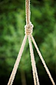 DESIGNER: CLARE MATTHEWS - SWINGING COCOON PROJECT: CLOSE UP OF ROPE KNOT ON COCOON FRAME HANGING FROM TREE