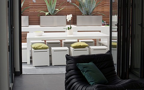 MINIMALIST_GARDEN_DESIGNED_BY_WYNNIATTHUSEY_CLARKE_VIEW_OUT_OF_THE_FLAT_TO_WHITE_METAL_TABLE_AND_CHA
