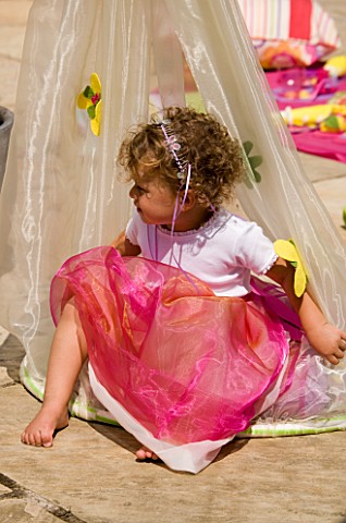 DESIGNER_CLARE_MATTHEWS_CHILDRENS_PARTY__GIRL_SITTING_IN_COCOON_ON_PATIO