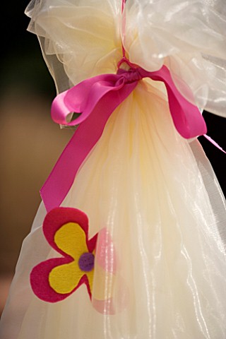 DESIGNER_CLARE_MATTHEWS_CHILDRENS_PARTY__DETAIL_OF_FLOWERS_AND_PINK_BOW_ON_COCOON
